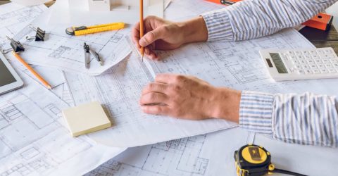 partial-view-of-architect-working-with-blueprints-2024-11-17-04-14-54-utc